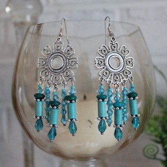 A pair of earrings with blue beads hanging from them.