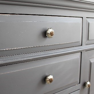 A close up of the drawers and knobs on a dresser