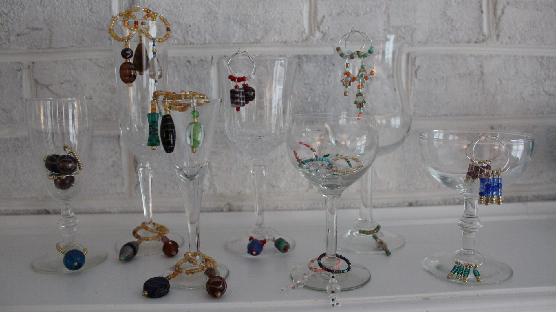 A table with wine glasses and jewelry on it.
