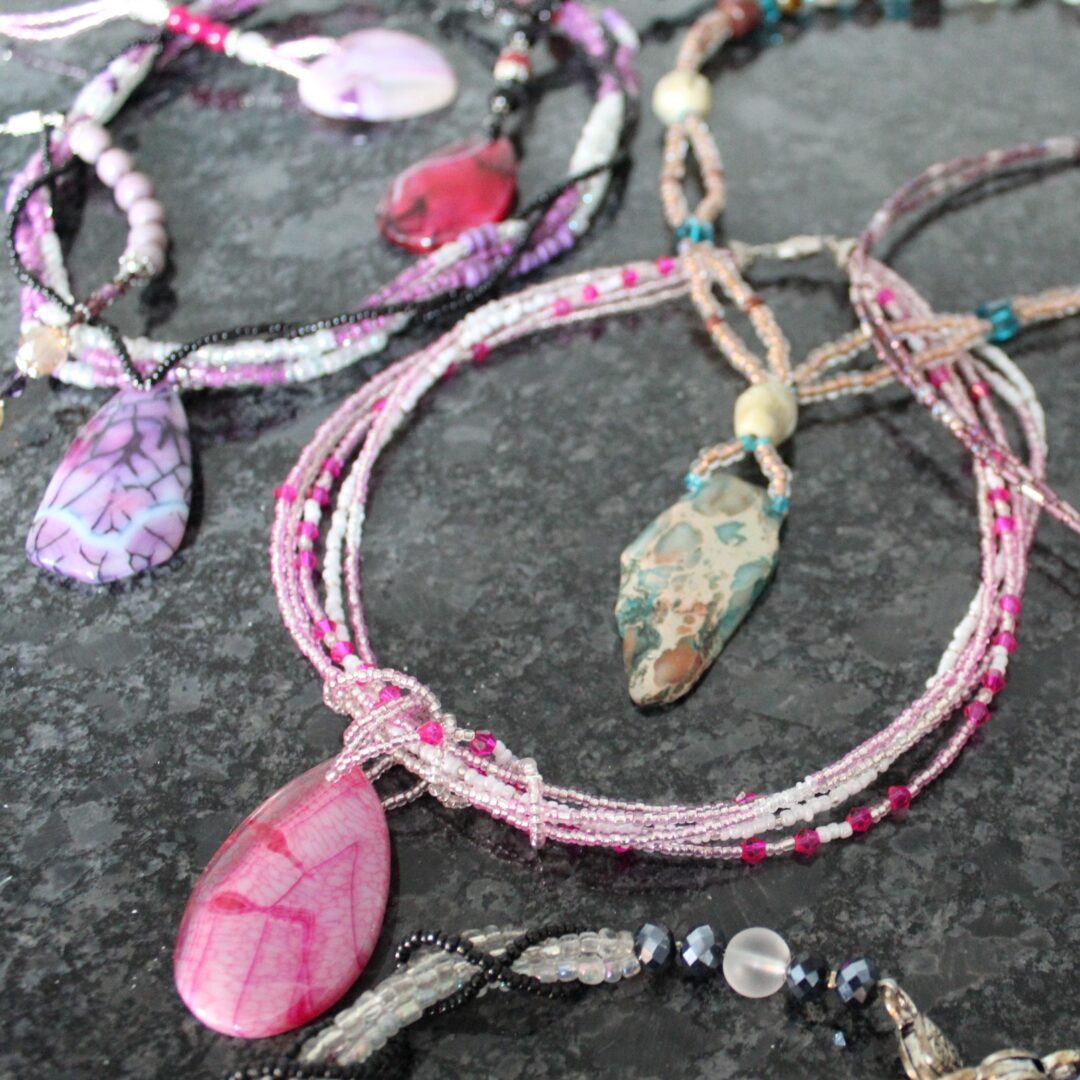 A close up of some necklaces on the ground