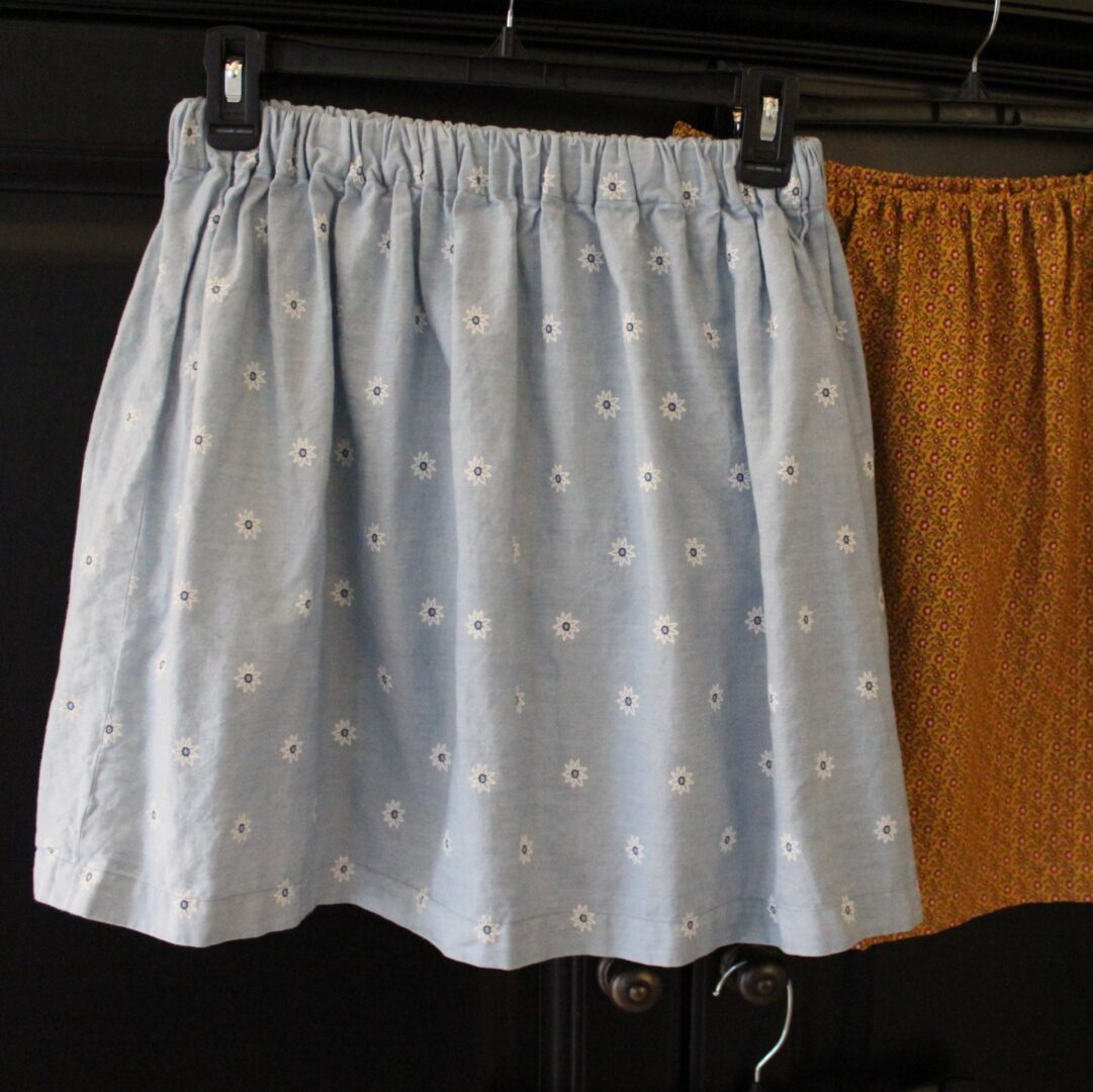 Two skirts hanging on a clothes line.