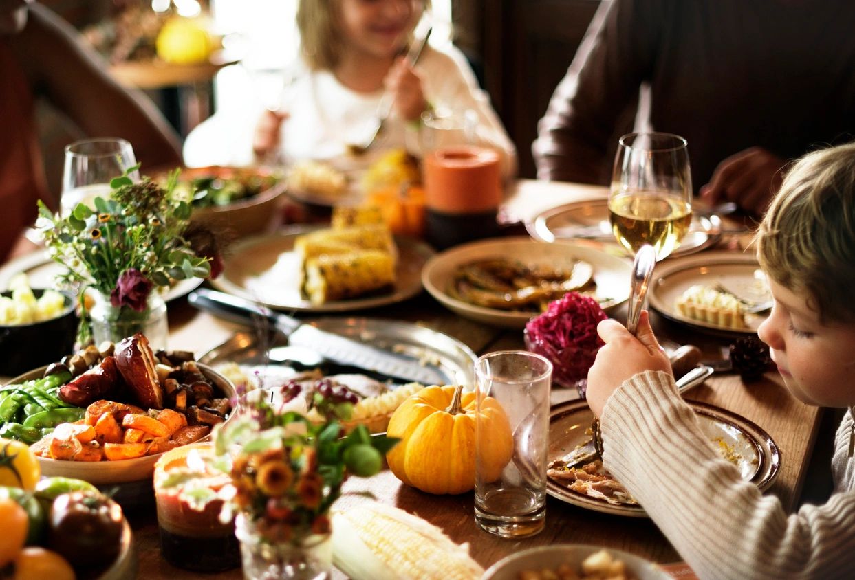 A group of people sitting at a table with food.