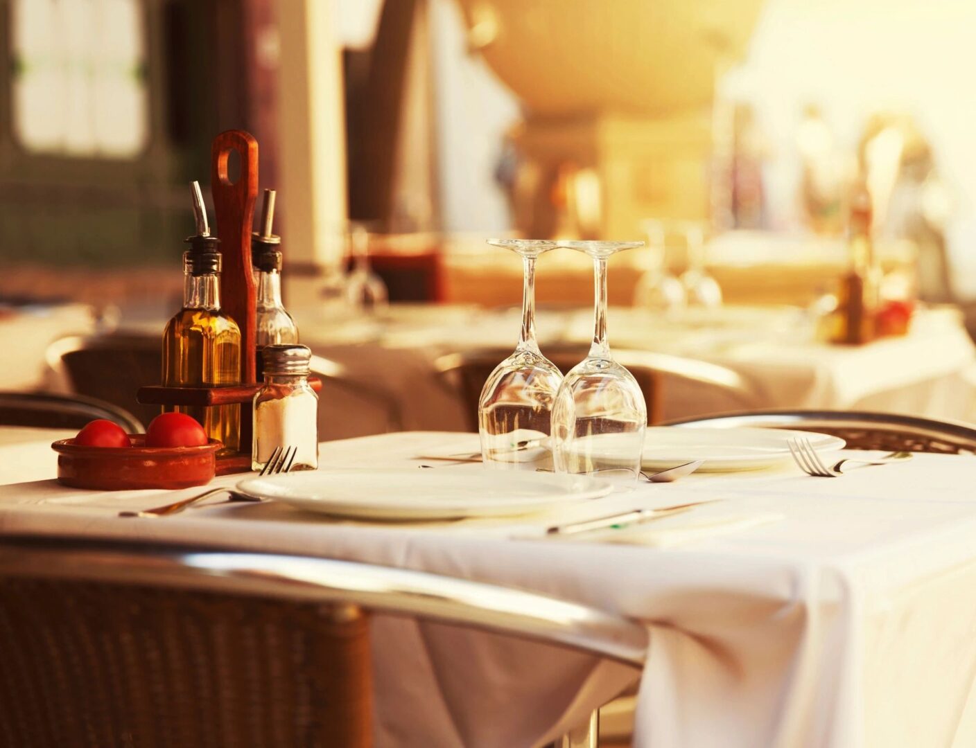 A table with wine glasses and silverware on it.